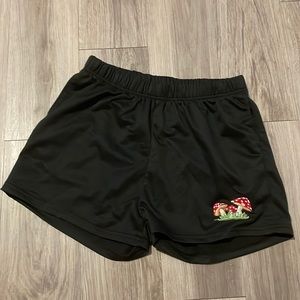 Black shorts with cute mushroom design on left leg.
